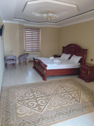 a bedroom with a large bed and a rug at Ramzan Family Guest House in Samarkand