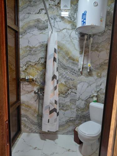 a bathroom with a toilet and a shower curtain at Ramzan Family Guest House in Samarkand
