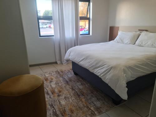 a bedroom with a large bed and a window at Northview APARTMENTS SELF CATERING in Pretoria