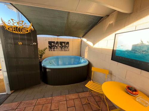 a bathroom with a tub in the corner of a room at Kowhai Motel Rotorua in Rotorua