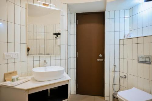 a bathroom with a sink and a toilet and a mirror at Kadkani River Resort Coorg in Siddapur