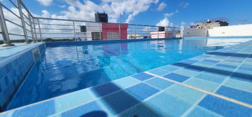 a swimming pool with a cruise ship in the background at Tulia Stays in Mtwapa