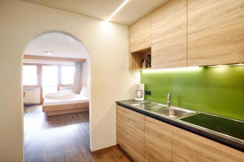 a kitchen with a sink and a green wall at Mountain Living Apartments in San Valentino alla Muta