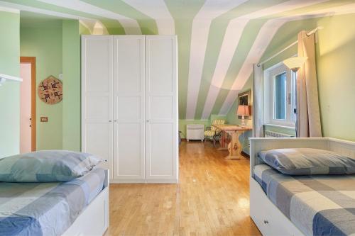 a bedroom with two beds and a striped ceiling at Bellagio House Antico Ulivo in Bellagio