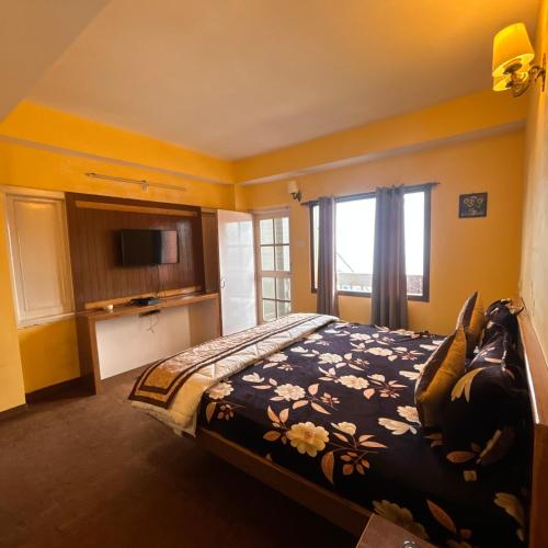 a bedroom with a bed and a television in it at Hotel Aman in Nārkanda