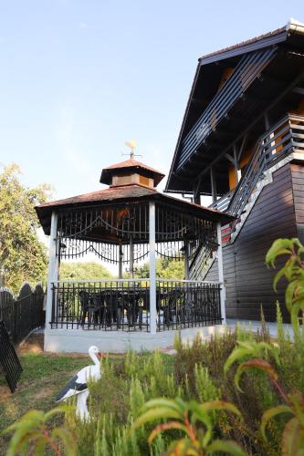 a pavilion with a table and chairs in front of a building at Villa Ferra in Virovitica