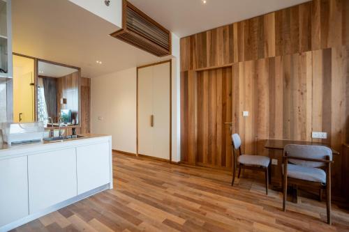 a kitchen with wooden floors and a table and chairs at Stadion Residences in Phumĭ Prêk Chrey