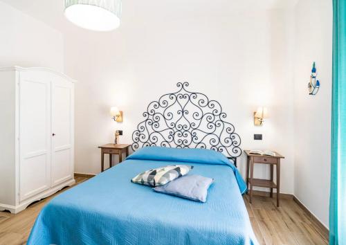 a bedroom with a blue bed with a large headboard at OLTREMARE in Scalea