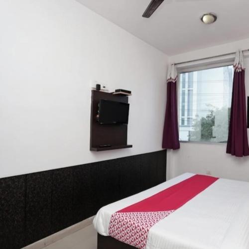 a bedroom with a bed and a tv on the wall at Taj wonder inn in Tājganj