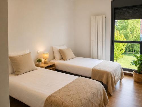two beds in a room with a window at El jardín de Cirueña in Cirueña