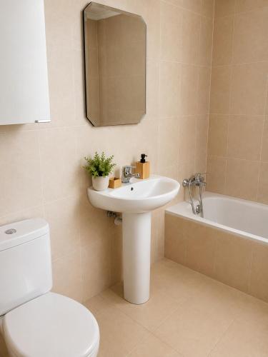 a bathroom with a toilet and a sink and a tub at El jardín de Cirueña in Cirueña