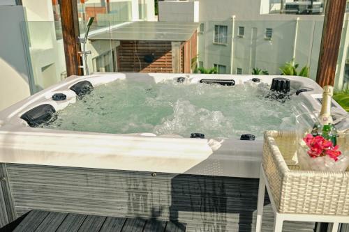 a jacuzzi tub on top of a balcony at Ocean Point Beachfront Penthouses by Gerards & Angel in Pointe aux Piments