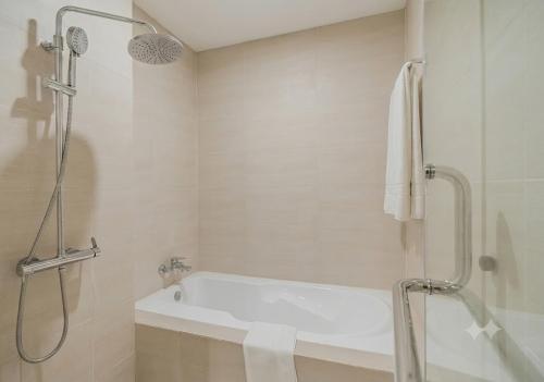 a bathroom with a shower and a bath tub at Axis Residences By The Team in Phnom Penh