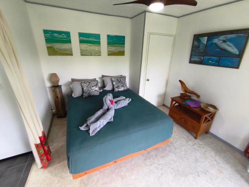 ein Schlafzimmer mit einem Bett mit Decken und einem Tisch in der Unterkunft Te Ava Piti Lodge in Uturoa