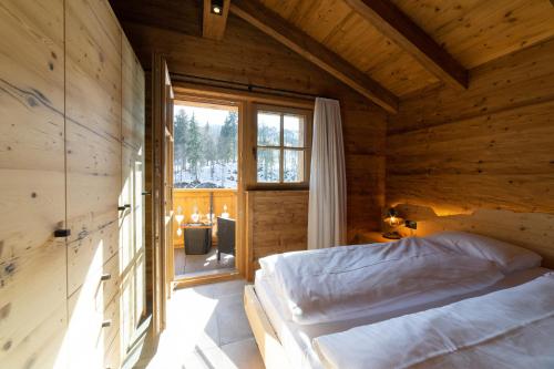 a bedroom with a bed in a wooden house at Chalet Schibenstoll - Luxury & Bergblick in Wildhaus