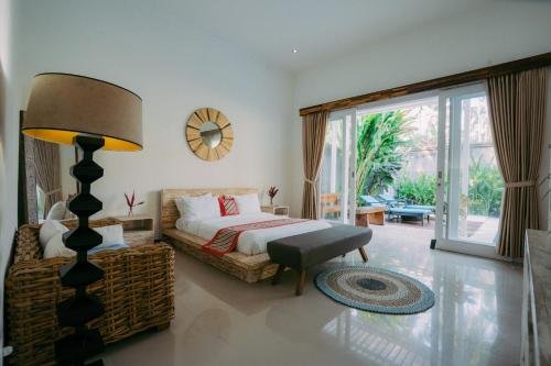 a bedroom with a bed and a table and a lamp at Luxury 3-Bedroom Villa with Private Pool in Pulukan
