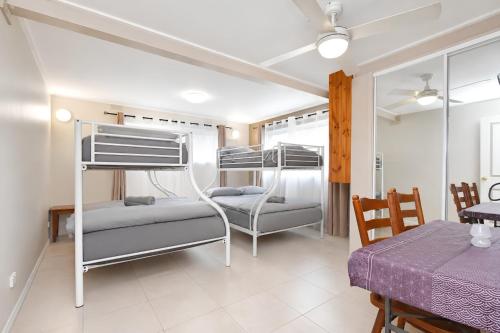 a bedroom with two bunk beds and a table at Coal d' Vine Chillout - Cessnock NSW in Cessnock
