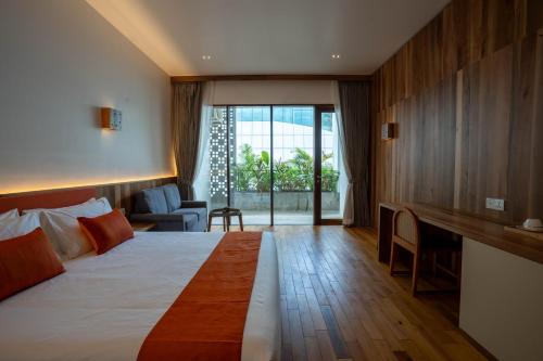 a hotel room with a large bed and a desk at Stadion Residences in Phumĭ Prêk Chrey