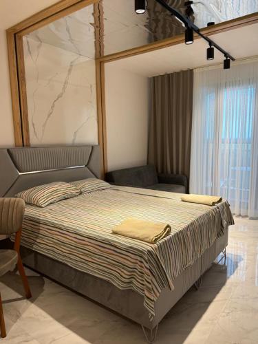 a large bed in a room with a chair at Azur properties 22 in Shkorpilovtsi