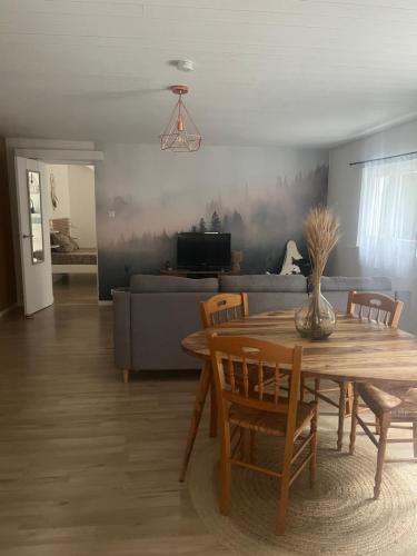a living room with a table and a couch at Lamaisondubois31 in Pibrac