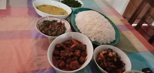 a table topped with bowls of food and rice at Secret Point Luxury Glamping in Panama