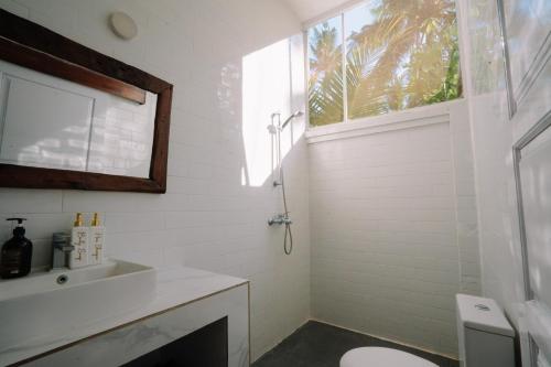 a bathroom with a sink and a toilet and a window at Luxury 3-Bedroom Villa with Private Pool in Pulukan