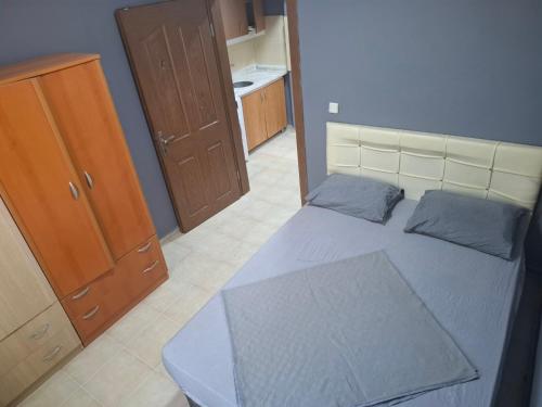 a small bedroom with a bed and a wooden cabinet at Ören örtur tatil evleri in Ören