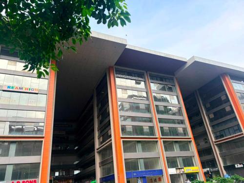 a large building with orange columns and windows at Collection O Airport Road Formerly Hotel Nano Pod in Surat