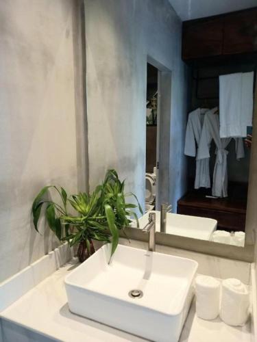 a bathroom with a white sink and a mirror at Kampot Tropical Resort 