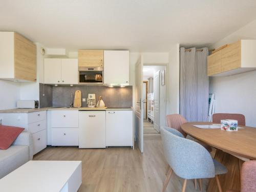 a kitchen and living room with a table and chairs at Les Grizzlis N 20 - 2P6 in Saint-Sorlin-dʼArves