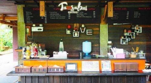 a restaurant with a counter with signs on the wall at Tamsabai Resort in Ban Na Nian