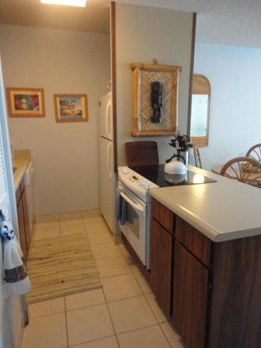 a small kitchen with a stove and a refrigerator at Maui Vista 1313 in Kihei