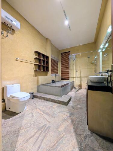 a bathroom with a tub and a toilet and a sink at Gangula Villa in Kandy