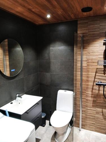 a bathroom with a toilet and a sink and a mirror at Vuokatti Weekend Grande in Vuokatti