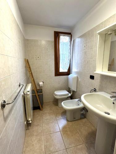 a bathroom with a toilet and a sink at PINK House in Schilpario