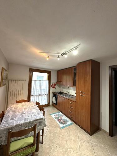 a kitchen with a table and a kitchen with a table and a kitchen at PINK House in Schilpario