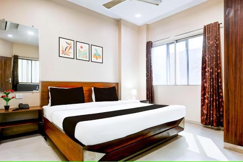 a bedroom with a large bed and a window at Hotel Swarat by TruStay in Satna