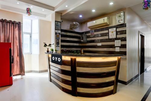 a bar in a room with a wall of wine bottles at Hotel Swarat by TruStay in Satna