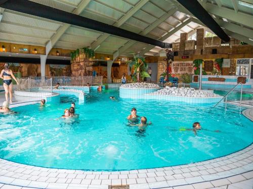 a group of people in a swimming pool at Charming Chalet Near Efteling in Kaatsheuvel