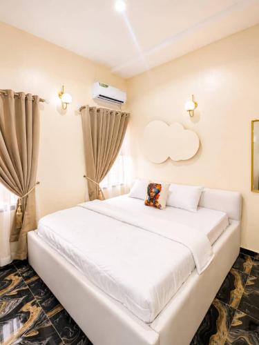 a white bedroom with a large white bed at Little Afrika in Port Harcourt