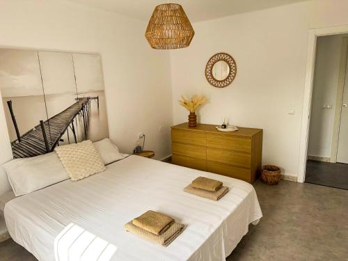 a bedroom with a white bed with two towels on it at La Chinita in Nerja