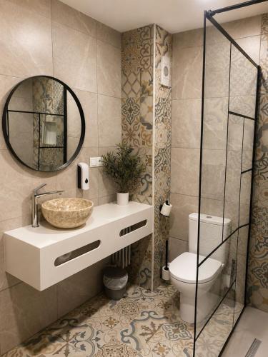 a bathroom with a sink and a toilet and a mirror at El Mirador del Espolon in Logroño