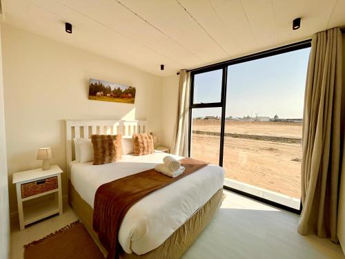 a bedroom with a bed and a large window at 42 on Kavango Unit 24 in Swakopmund