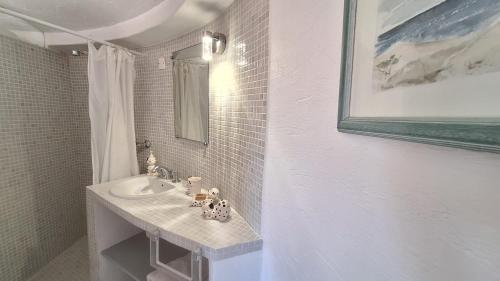 a white bathroom with a sink and a mirror at Villa Pibinson 3 chambres - piscine in Mougins