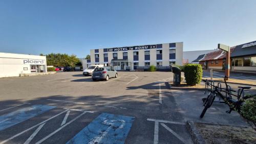 a parking lot with a car parked in front of a building at Hotel Le Rohu Vannes in Séné