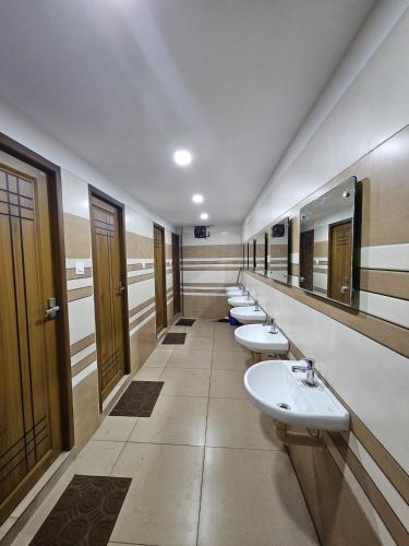 a row of sinks in a public restroom at Lowfare Dormitory in Kozhikode