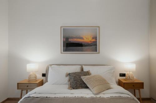 a bedroom with a bed with two night stands and two lamps at The Edge Piraeus Luxury Residences in Piraeus