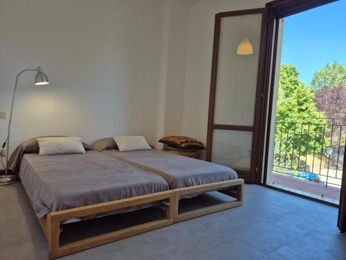 a bed in a room with a large window at Santarcangelo Stay Your Perfect Base in Romagna in Santarcangelo di Romagna