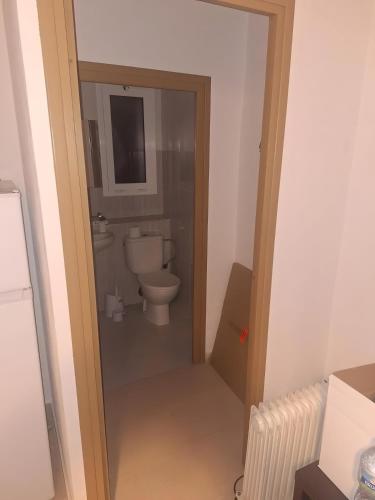 a bathroom with a toilet and a door open at Mas De La Salut in Sant Jaume Sas Oliveras