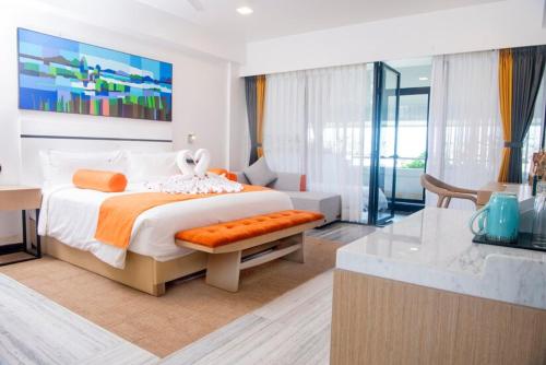 a white bedroom with a large bed and a desk at Paciano in Jalpāiguri